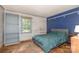 Cozy bedroom with blue accent wall, wood-style flooring and natural light at 417 Phifer Rd, Kings Mountain, NC 28086