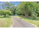 Long paved driveway leading to a charming home surrounded by lush greenery and mature trees at 417 Phifer Rd, Kings Mountain, NC 28086