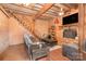 Cozy living room features brick fireplace, wood paneled walls, exposed beam ceiling, and staircase to upper level at 417 Phifer Rd, Kings Mountain, NC 28086