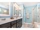 Well-lit bathroom with double sinks, modern fixtures, and a glass-enclosed shower stall at 5092 Nighthawk Dr, Indian Land, SC 29707