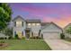 Charming two-story home featuring a manicured lawn, attached two-car garage, and beautiful landscaping at 5092 Nighthawk Dr, Indian Land, SC 29707