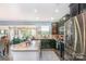 The kitchen with stainless steel appliances and granite island flows to the sitting room at 5092 Nighthawk Dr, Indian Land, SC 29707