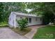 Side view of a cozy home with white siding, metal roof, concrete patio, and walkway to the driveway at 535 Norman Fair Ave, Lincolnton, NC 28092