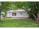 Charming single-story home with white siding, metal roof, and mature trees surrounding the property at 535 Norman Fair Ave, Lincolnton, NC 28092