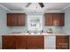 Close-up of kitchen with wood cabinets, modern countertops, stainless steel sink, and a dishwasher at 535 Norman Fair Ave, Lincolnton, NC 28092