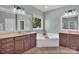 Bright bathroom featuring double sinks, garden tub, and natural light from a large window overlooking the backyard at 6004 Trailwater Rd, Charlotte, NC 28278