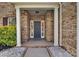 Inviting entryway showcasing a brick-lined porch and gray front door framed by white columns and landscaping at 6004 Trailwater Rd, Charlotte, NC 28278