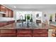 Bright kitchen island with granite countertops, wood cabinets, and stainless-steel fixtures at 6004 Trailwater Rd, Charlotte, NC 28278