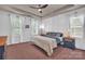 Stylish bedroom with a tray ceiling, modern ceiling fan, two windows and lovely decorative wall paneling at 6004 Trailwater Rd, Charlotte, NC 28278
