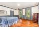 Charming bedroom with hardwood floors, soft blue accents, and bright windows dressed in floral curtains at 704 Little Creek Dr, Kings Mountain, NC 28086