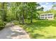 Picturesque home nestled in a wooded setting with a lush green lawn and a long driveway at 704 Little Creek Dr, Kings Mountain, NC 28086