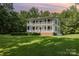 Beautiful two-story home at sunset, surrounded by mature trees and a well-manicured green lawn at 704 Little Creek Dr, Kings Mountain, NC 28086