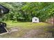 The spacious backyard features a shed, a wood fence, and many mature trees for privacy at 704 W Border St, Dallas, NC 28034