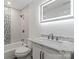 This bathroom features an illuminated mirror, modern fixtures, and a shower/tub combo at 704 W Border St, Dallas, NC 28034