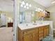 Clean bathroom with double sink vanity, decorative mirror, and wooden cabinet at 7300 Bailywick Dr, Waxhaw, NC 28173