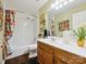 Well-lit bathroom with a tub and shower combination, a wooden vanity and vibrant decor at 7300 Bailywick Dr, Waxhaw, NC 28173