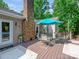 Deck features a table with chairs, a brick chimney, an awning, a grill, and a white door leading to a backyard at 7300 Bailywick Dr, Waxhaw, NC 28173