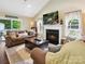 Cozy living room with a fireplace, large windows, and comfortable seating, perfect for relaxation at 7300 Bailywick Dr, Waxhaw, NC 28173