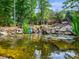 Pond with waterfall surrounded by rocks, trees, and plants at 7300 Bailywick Dr, Waxhaw, NC 28173