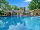 Backyard pool featuring an awning, chimney, covered porch and a wooded backdrop at 7300 Bailywick Dr, Waxhaw, NC 28173