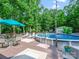 Outdoor pool area featuring lounge chairs, table with chairs, an above ground pool and wooded backdrop at 7300 Bailywick Dr, Waxhaw, NC 28173