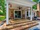 Back porch area featuring a fan, rocking chairs, string lights and brick pavers at 7300 Bailywick Dr, Waxhaw, NC 28173