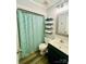 Cozy bathroom with patterned shower curtain, vanity with sink, and floating shelves for storage at 734 Forestbrook Dr # 10, Gastonia, NC 28056