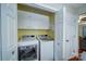 Conveniently located laundry room featuring a white washer and dryer and upper cabinet storage at 734 Forestbrook Dr # 10, Gastonia, NC 28056