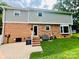 Brick back exterior featuring an access door, steps to the backyard, and a well-maintained lawn at 734 Forestbrook Dr, Gastonia, NC 28056