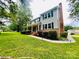 Well-maintained two-story home featuring gray siding, black shutters, and a lush green lawn at 734 Forestbrook Dr, Gastonia, NC 28056