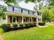 Beautifully maintained home with a brick porch, rocking chairs, and a well-manicured front yard at 734 Forestbrook Dr, Gastonia, NC 28056