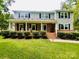 Charming two-story home with a brick facade, covered porch, and meticulously landscaped front yard at 734 Forestbrook Dr, Gastonia, NC 28056