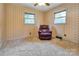 Bedroom featuring neutral carpet, two bright windows, and a comfortable, purple recliner at 888 Stowe Ln, Gastonia, NC 28056