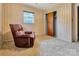 Bedroom featuring neutral carpet, bright window, closet and a comfortable, brown recliner at 888 Stowe Ln, Gastonia, NC 28056