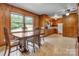 Vintage eat-in kitchen with wood-paneled walls, classic cabinets, and bright window at 888 Stowe Ln, Gastonia, NC 28056