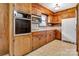 Original kitchen with wood cabinets, vintage appliances, and neutral flooring at 888 Stowe Ln, Gastonia, NC 28056
