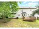 Backyard with mature trees, a wooden deck, and green lawn, creating a private outdoor space at 9146 Austin Ridge Ln, Charlotte, NC 28214