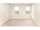 Neutral bedroom features carpeted floor, two windows with blinds, and a white door at 9146 Austin Ridge Ln, Charlotte, NC 28214