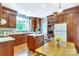 Spacious kitchen with a central island, wooden cabinets, and stainless steel appliances, blending classic design with modern amenities at 1021 Isleworth Ave, Charlotte, NC 28203
