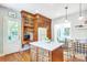 A well-lit kitchen featuring wood cabinets, stainless steel appliances, an island, and desk, offering both style and functionality at 1021 Isleworth Ave, Charlotte, NC 28203