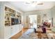 Inviting living room with built-in shelving, TV, with a seamless flow to a sunlit area, perfect for relaxation and entertainment at 1021 Isleworth Ave, Charlotte, NC 28203