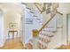 Bright staircase features wood steps, white railings, and decorative artwork on the walls at 1021 Isleworth Ave, Charlotte, NC 28203