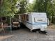 Prowler camper with awning extended, a golf cart, and outdoor seating at 103 Powder Horn Trl, Mount Gilead, NC 27306
