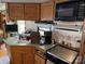 Camper kitchen featuring oak cabinets, a microwave, and oven at 103 Powder Horn Trl, Mount Gilead, NC 27306