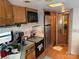 Camper kitchen with stainless steel fridge, microwave, oak cabinets, and tile flooring at 103 Powder Horn Trl, Mount Gilead, NC 27306
