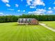 Stunning aerial view of a brick home with a meticulously maintained lawn and surrounding landscape at 106 Laren Rd, Shelby, NC 28152