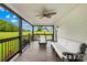 Inviting covered porch with white furniture, ceiling fan, and serene views of the surrounding green landscape at 106 Laren Rd, Shelby, NC 28152