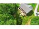 An aerial view of a home with a lush backyard featuring a stone patio, fire pit, and mature landscaping at 110 St Sophia Ct, Mooresville, NC 28117