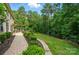 A lush backyard featuring a stone patio with outdoor seating and a well-manicured lawn backing up to a wooded area at 110 St Sophia Ct, Mooresville, NC 28117