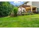 Spacious backyard featuring a retaining wall with steps and lush green grass, perfect for outdoor activities and relaxation at 110 St Sophia Ct, Mooresville, NC 28117